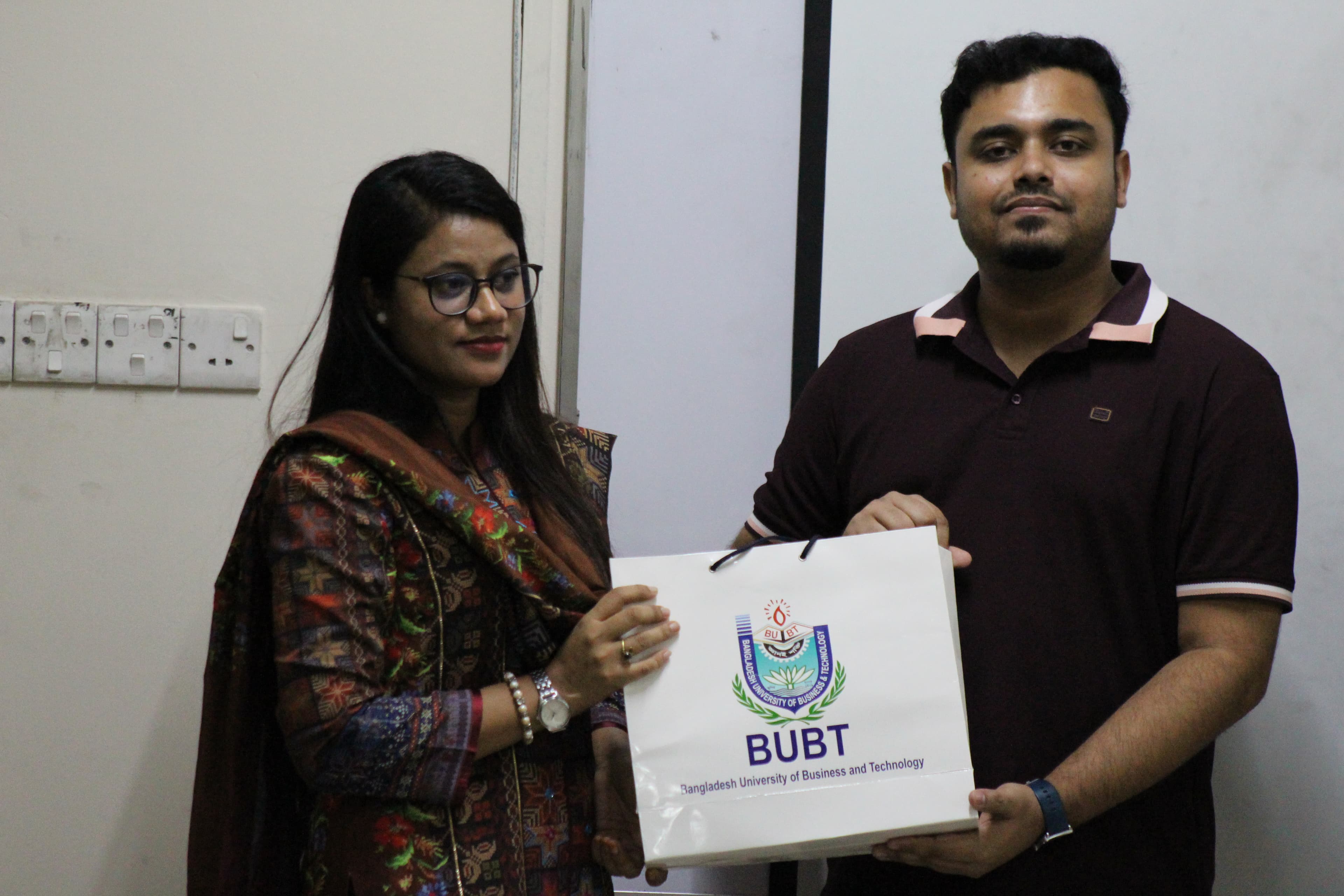 A BUBT representative presenting a university gift bag to the BugBoundQA trainer at the close of the workshop.
